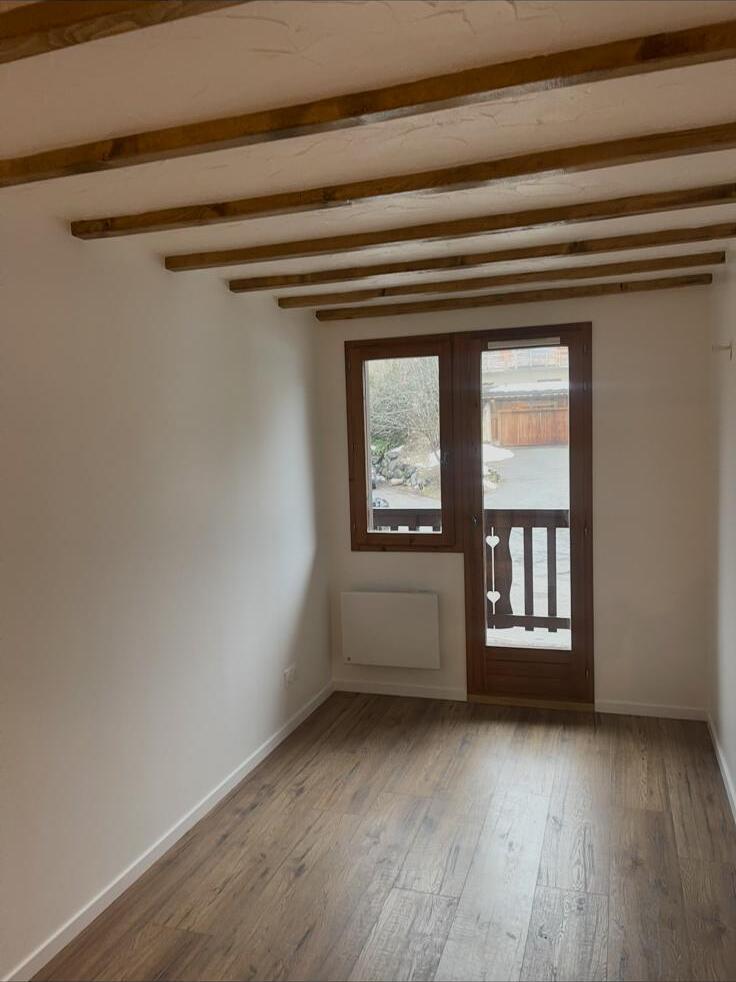 Re-plastered cottage room with crisp walls and ceiling around exposed structural beams