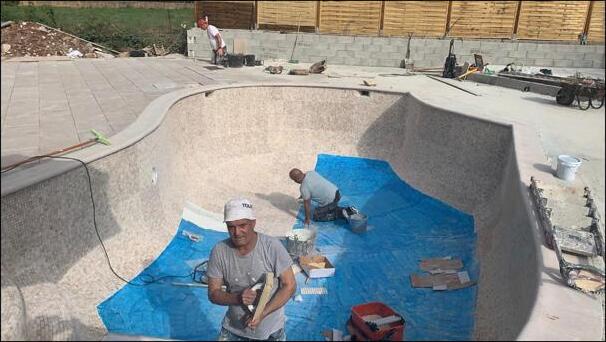 SJM Plastering team applying sand-and-cement external render to a swimming pool basin in Hampshire